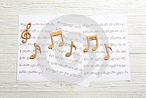 Sheets and music notes on light wooden background