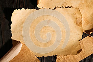 Sheets of old parchment paper on wooden table, flat lay