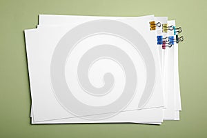 Sheets of paper with clips on light green background