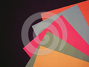 Sheets of paper of different colors on a black background