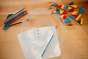 Sheets of paper with math and writing tasks on a wooden table