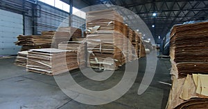 Sheets of plywood slabs are stacked in the warehouse of the woodworking plant