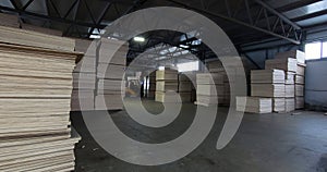 Sheets of plywood slabs are stacked in the warehouse of the woodworking plant