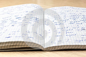 Sheets of school student notebook scribbled with a blue ballpoint pen.