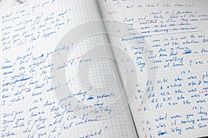 Sheets of school student notebook scribbled with a blue ballpoint pen.