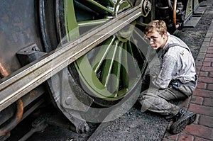 SHEFFIELD PARK, EAST SUSSEX/UK - SEPTEMBER 8 : Unidentified young Man cleaning a steam train wheel at Sheffield Park station East