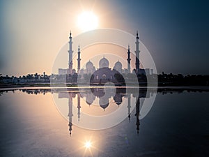 Sheikh Zayed Grand Mosque with reflection on water and a beautiful sunset view