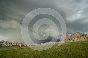 A shelf cloud accompanies this thunderstorm as it approaches a rocky hillside.