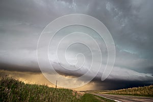 A shelf cloud and thunderstorm in the sky over a highway in the grasslands of Nebraska