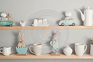 Shelf with dishes. Kitchenware on wooden shelves. Kitchen interior Easter background. Minimalistic cozy light home style.