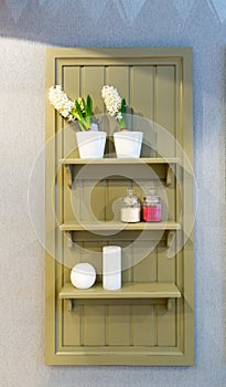 Shelf with flowers and cosmetics