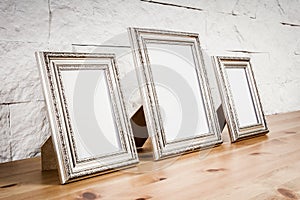 Shelf with frames and white wall