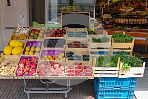 Shelf with fresh fruits and herbs in greengrocery store