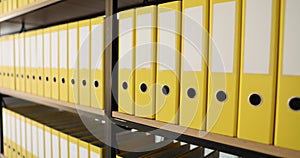 Shelf full of identical yellow office folders