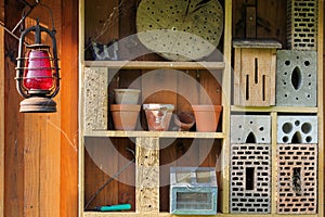 Shelf with insect hotel and garden utensils