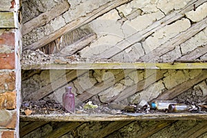 Shelf with old things in a ruined wooden house in an abandoned village