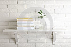 Shelf with stack of hardcover books hanging on wall