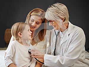 Shell get the help she needs. Shot of a doctor examining a little girl and her mother with a stethoscope in bed at home.