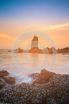 Shell rock over seacoast with sunset sky