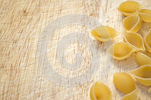 Shell shaped pasta on wooden background