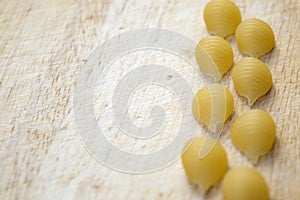 Shell shaped pasta on wooden cutting board