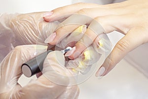 Shellac coating master applies nail polish to client photo