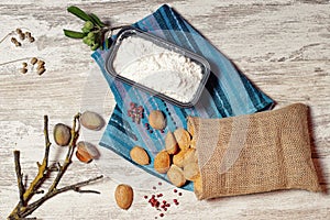 Almonds in a cloth bag and container with flour III photo