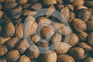 Shelled almonds nuts as background. Heap of almonds texture and background for design. Close up view of almonds in their shells.