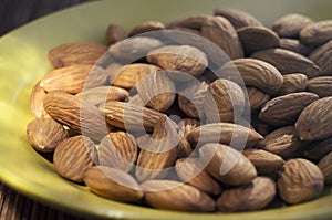 Shelled almonds Prunus dulcis, Prunus amygdalus on a plate. Closeup view