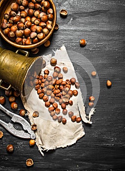 Shelled hazelnuts with Nutcracker and mortar of the old fabric.