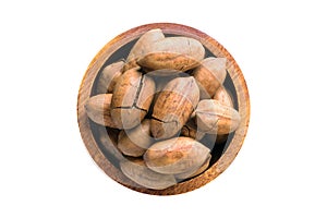 Shelled pecan nuts fried with cocoa butter in wooden bowl isolated on white background. Vegan food, top view