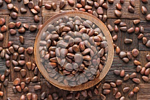 Shelled pine nuts in wooden bowl, top view