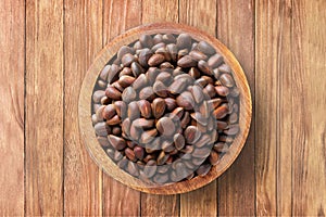 shelled pine nuts in bowl on wooden table background, top view. organic vegetarian food