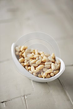 Shelled pine nuts in a white bowl