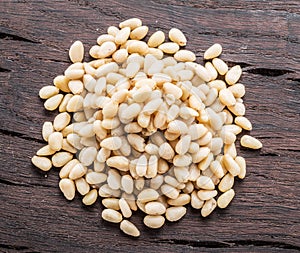 Shelled pine nuts on the wooden table. Top view. Organic food