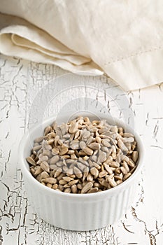 Shelled sunflower seeds in bowl on rustic white table