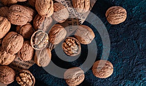 Shelled and unshelled walnuts on dark grunge background. Top view, flat lay with copy space