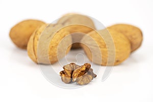 Shelled walnuts and walnuts in shell on white background photo