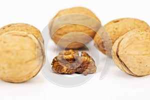 Shelled walnuts and walnuts in shell on white background photo