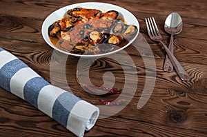 Shellfish seafood. Hot fresh italian appetizing steamed mussels in tomato sauce with olives and red pepper on vintage wooden table