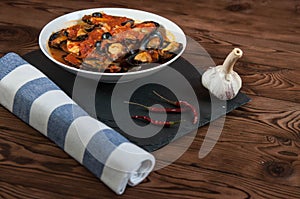 Shellfish seafood. Hot fresh italian appetizing steamed mussels in tomato sauce with olives and red pepper on vintage wooden table
