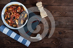 Shellfish seafood. Hot fresh italian appetizing steamed mussels in tomato sauce with olives and red pepper on vintage wooden table