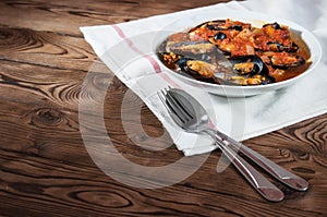 Shellfish seafood. Hot fresh italian appetizing steamed mussels in tomato sauce with olives and red pepper on vintage wooden table