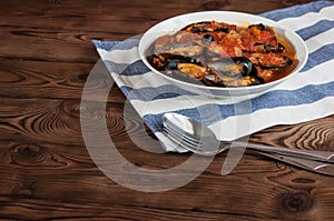 Shellfish seafood. Hot fresh italian appetizing steamed mussels in tomato sauce with olives and red pepper on vintage wooden table