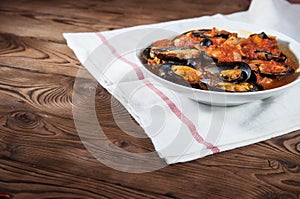 Shellfish seafood. Hot fresh italian appetizing steamed mussels in tomato sauce with olives and red pepper on vintage wooden table