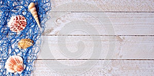 Shells with blue fishing net on wooden background
