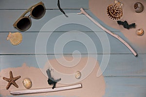 Shells with sand on a blue wood background .