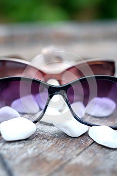 Shells, sand and sunglasses on a wooden table