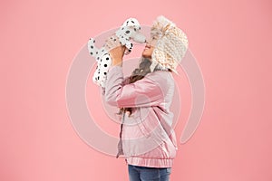 Shelter for animals. Dalmatian dog. Games kids play. Happy small smiling child play with soft dog on pink background