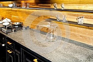 Shelves with collection of decorative glasses on wooden wall in kitchen